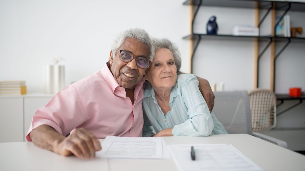 Senior couple reviewing paperwork together at a table